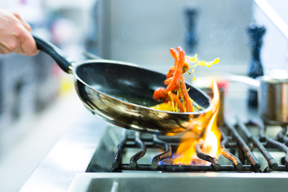 Chef,In,Restaurant,Kitchen,At,Stove,With,Pan,,Doing,Flambe